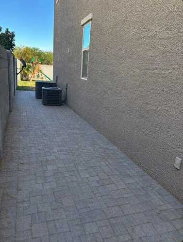 Cleared paved passage beside a stucco home