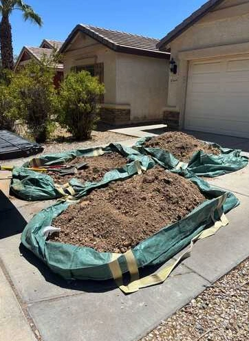 Yard debris gathered on tarps in an Arizona driveway